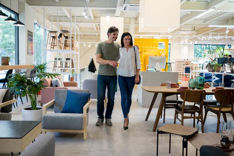 A couple walks through a furniture store together