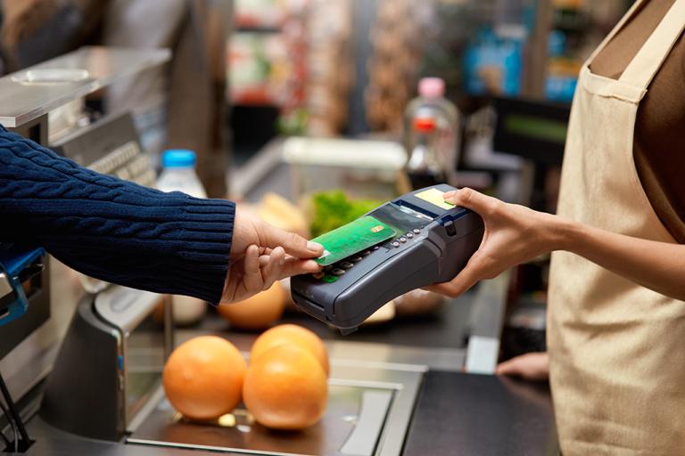 A customer pays for groceries with a credit card