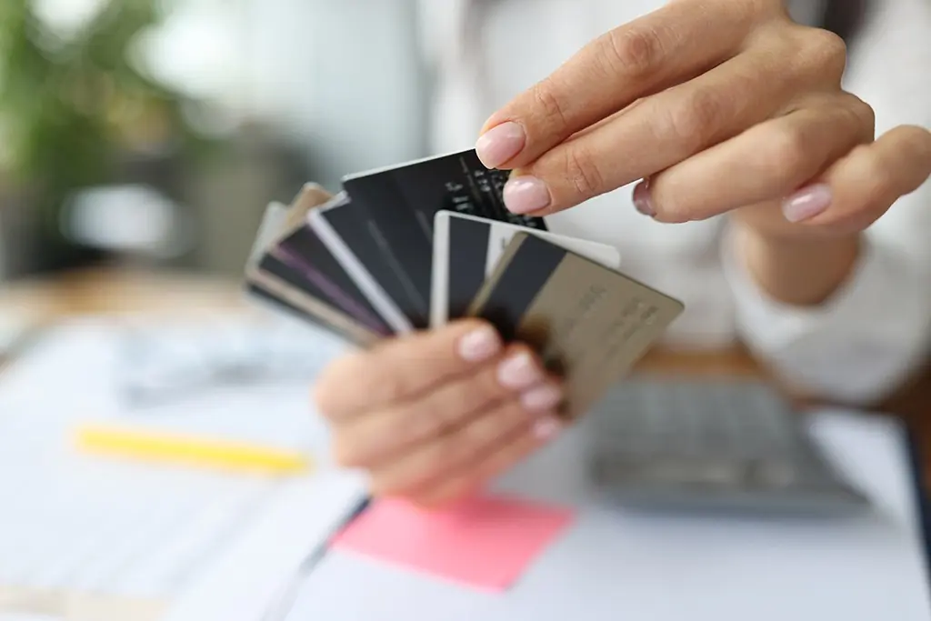 Person fans out a handful of credit cards, reaching for one