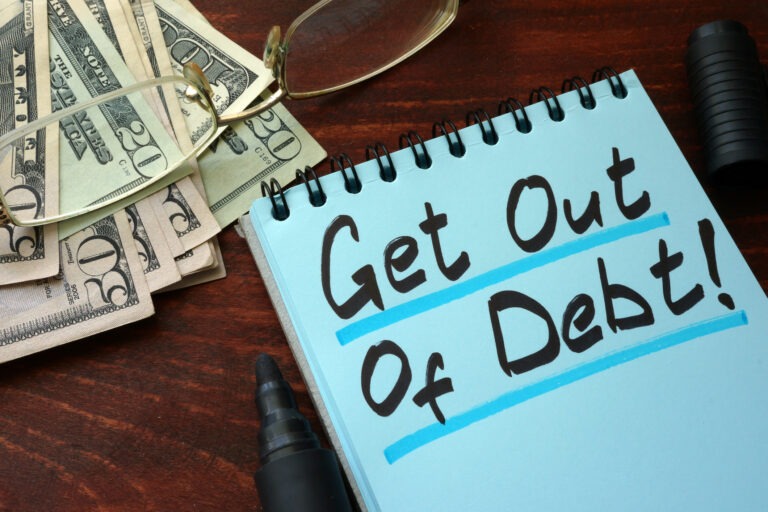 Get out of Debt written on a notepad with marker.