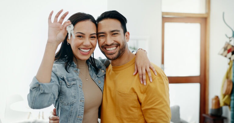 Couple with keys to their first home after debt settlement