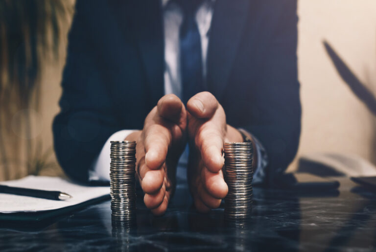 Man in suit dividing stack of coins signifying divorce