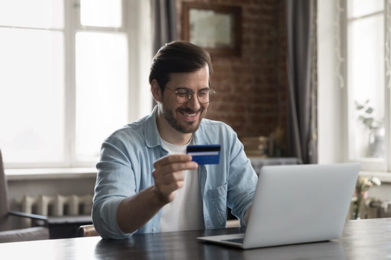 Man at laptop using balance transfer credit card