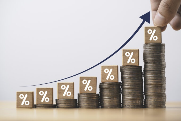 Increasing coin stacking with up arrow. High interest rates concept.