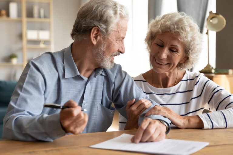 Couple signing paper to cash out policy with life settlement