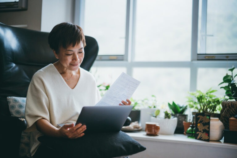 Woman at desk looking at debt report and wondering how to stop interest