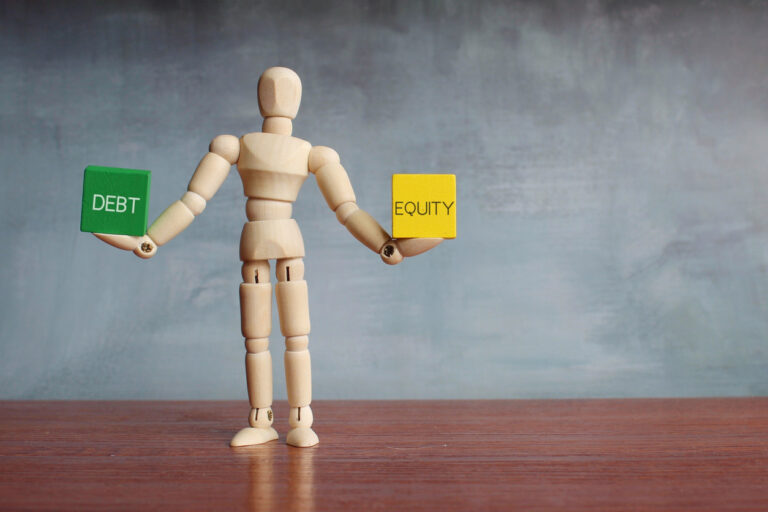 Debt and equity balance concept. Figurine holding cubes.