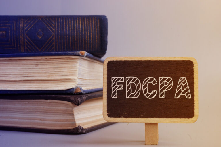 Stack of books with sign that says FDCPA