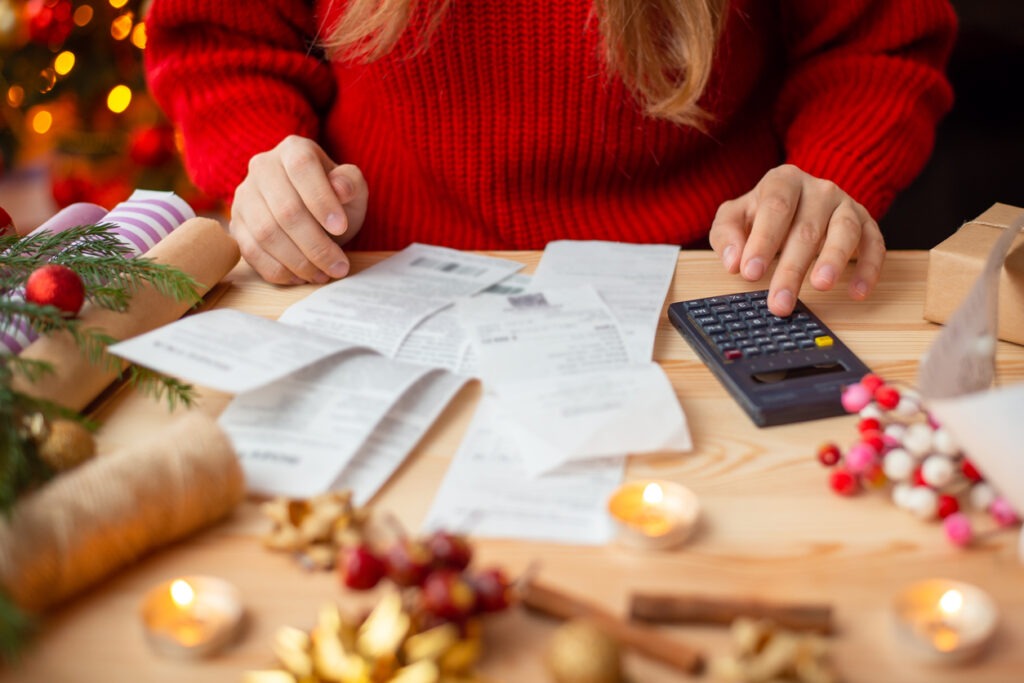 Woman sitting at the table, checking her bills after buying everything for Christmas