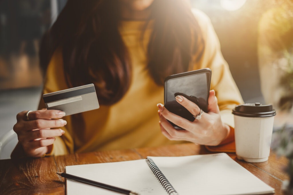 Woman looking at credit score wondering what will happen if she pays off debt