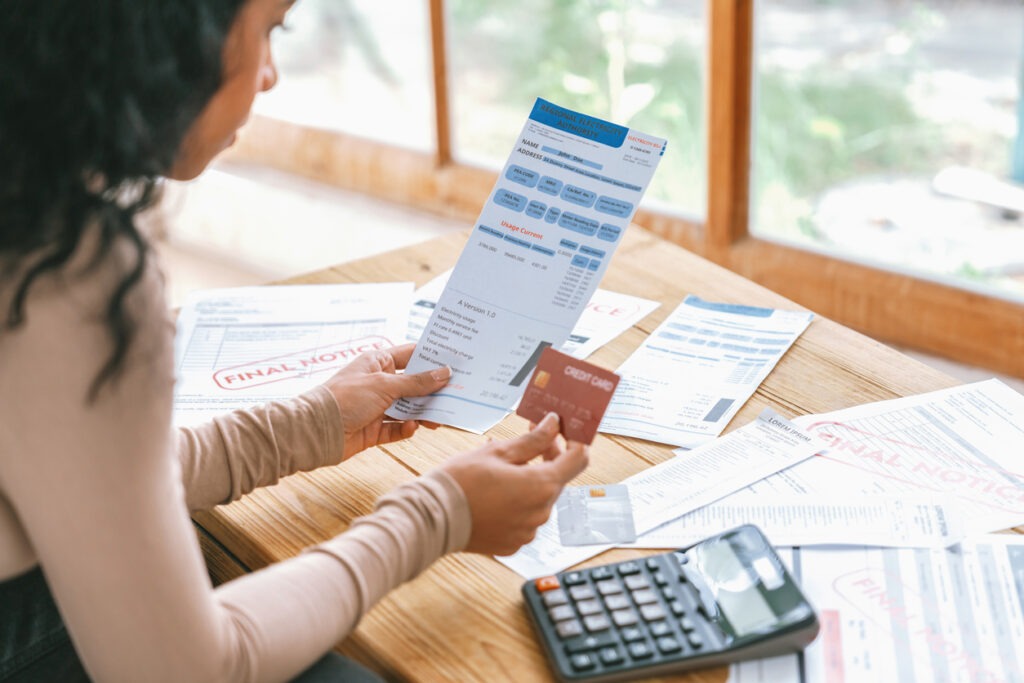 Woman looking over her bills, deciding what to pay first