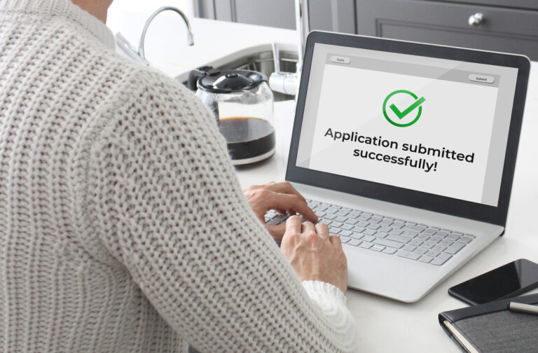 Person submitting online application at kitchen island