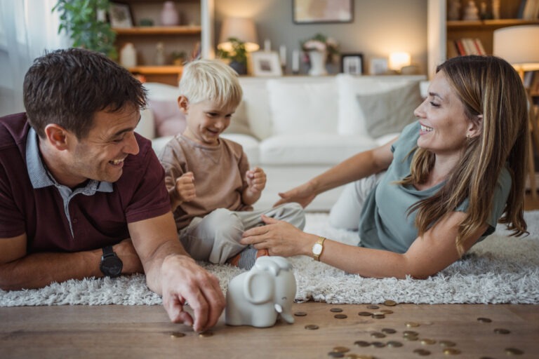 Mother and father with young son. Playing with "piggy" bank