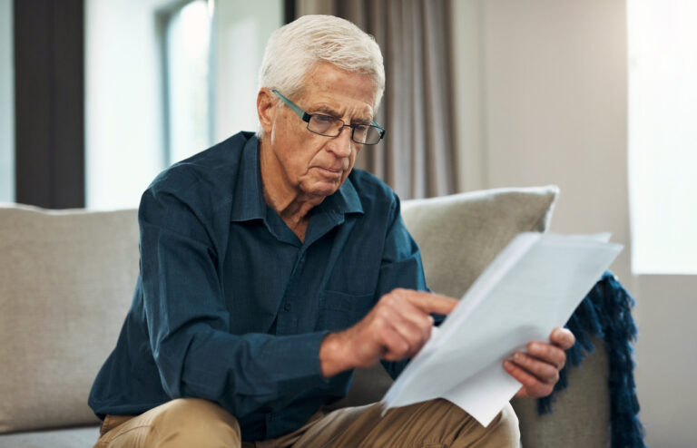 Man looking at insurance policy, deciding what option is best