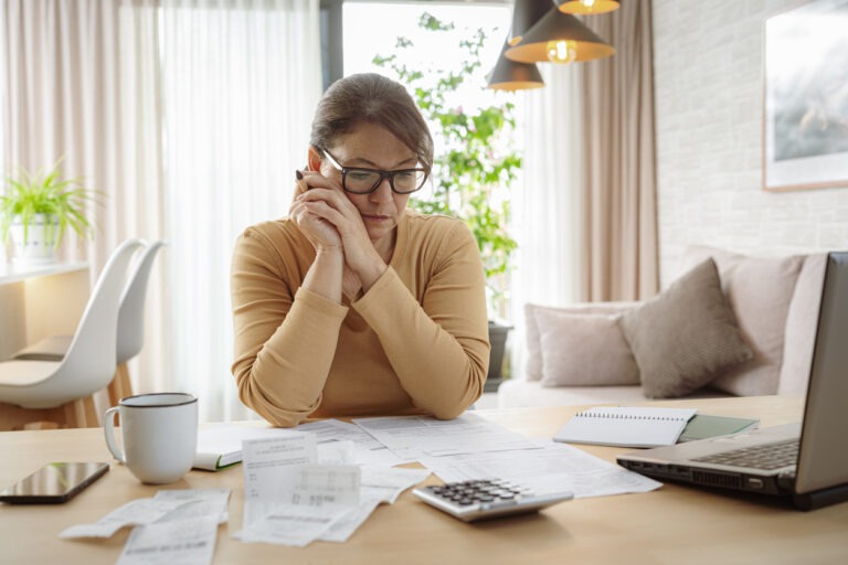 Woman at table calculating finances and debt