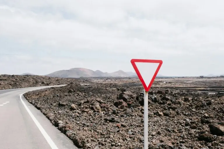 Yield shaped road sign on side of desert highway