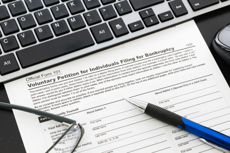 Close up of a bankruptcy form on desk with keyboard, mouse and pen